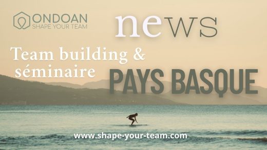 Un surfeur seul au coucher du soleil, avec les montagnes basques en arrière-plan, symbole de dépassement de soi et d’inspiration