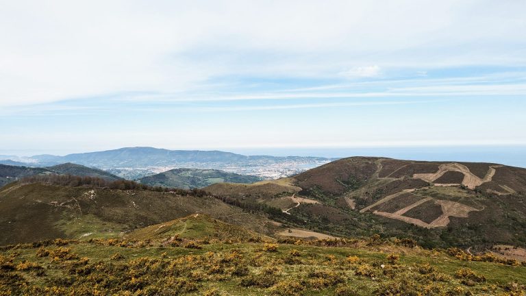 Vue sur la frontière espagnole depuis les montagnes du Pays Basque, illustrant l'ouverture culturelle pour un séminaire à Biarritz.