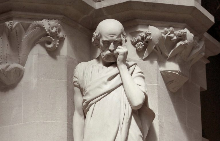 Statue d'Hippocrate en train de réfléchir, symbolisant les racines antiques du modèle DISC et la quête de compréhension des tempéraments humains.